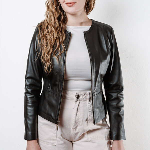 Mujer usando un blazer de piel color negro 'Magnolia Nocturna' de Gerhel con corte entallado.