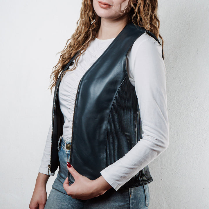 Mujer usando chaleco de piel de borrego azul 'Silueta' de Gerhel con ajuste lateral.