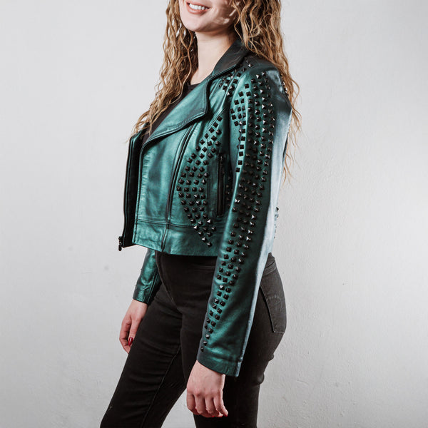 Mujer usando chamarra biker de piel verde metálico con estoperoles negros modelo 'Rockstar' de Gerhel.