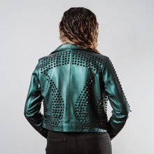 Mujer usando chamarra biker de piel verde metálico con estoperoles negros modelo 'Rockstar' de Gerhel. Vista trasera.