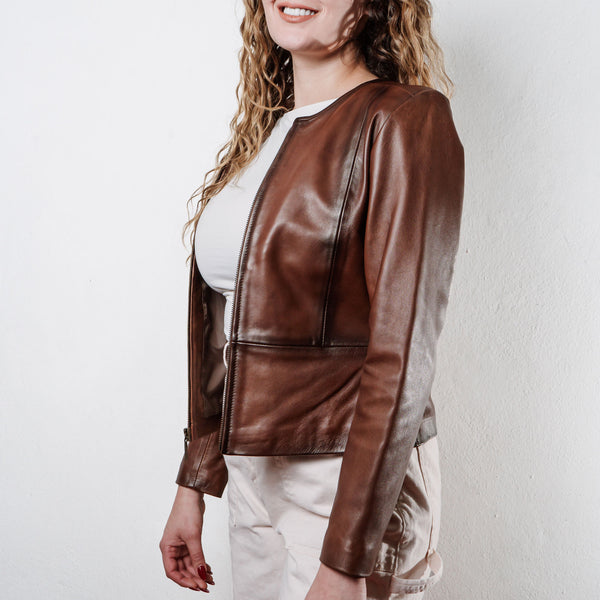 Mujer usando chamarra de piel color café 'Magnolia Otoñal' de Gerhel con cuello redondo y corte entallado.