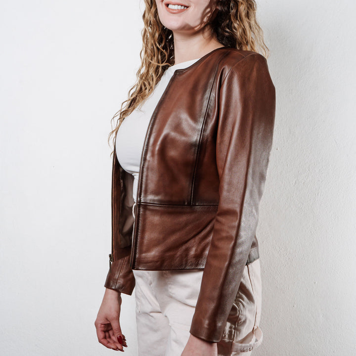 Mujer usando chamarra de piel color café 'Magnolia Otoñal' de Gerhel con cuello redondo y corte entallado.