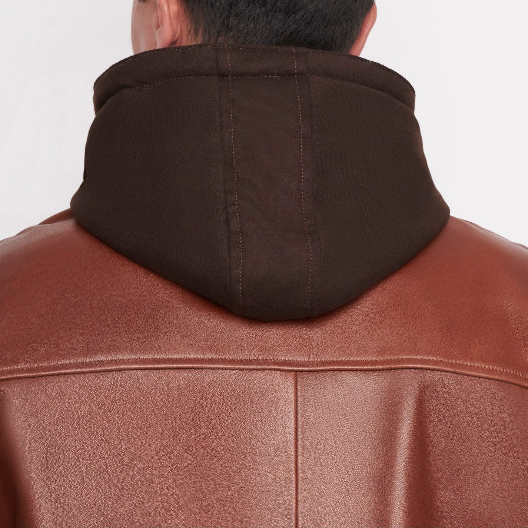 Detalle de capucha de chamarra 'Híbrida' 1141 de piel de borrego negra con capucha textil desmontable.
