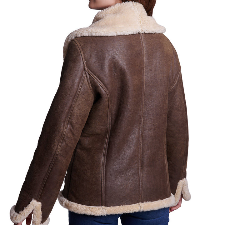Mujer de espaldas usando chamarra clásica de piel de borrego café 319 con botones al frente, ideal para el frío.